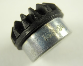 May include: A silver gear with a black rubber ring and the number 163986 printed on it.