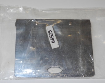May include: A silver metal plate with a round hole in the center. The plate has a label with the number 9952 on it.