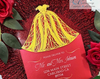 May include: A red envelope with a yellow laser-cut design of a wedding dress on top. The envelope has the text "PLEASE DELIVER TO Mr. and Mrs. Johnson 1234 MAIN STREET CARLSBAD CA 89704" printed on it.