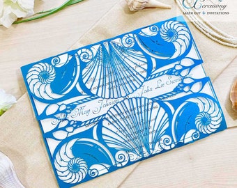 May include: Blue laser cut wedding invitation with a seashell design. The invitation reads "Mr. & Mrs. May Johnson to John Lee Succellia, Saturday, the Seventh Day of May, the Evening at Five Thirty."