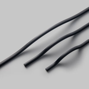 以下が含まれることがあります： 湾曲したデザインの黒い金属製のキャビネットハンドル3つ。ハンドルはサイズが異なります。