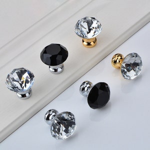 以下が含まれることがあります： さまざまなスタイルのクリスタル製キャビネットノブ6個。クリアクリスタルノブが3個、ブラッククリスタルノブが3個あります。ノブはシルバーまたはゴールドのベースが付いています。