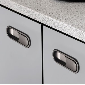 May include: Two grey cabinet doors with black, rectangular, recessed cabinet pulls.