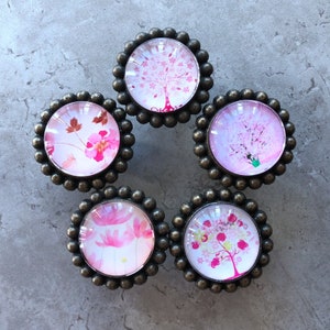 Può includere: Sei pomelli per mobili in stile antico con un bordo perlato. Ogni pomello presenta un motivo floreale rosa e bianco con una cupola di vetro.