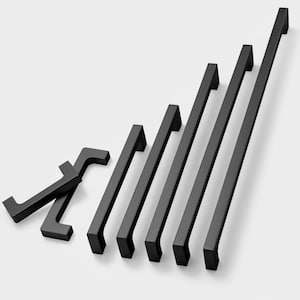 Op de afbeelding: Een set van zeven zwarte metalen kastgrepen in verschillende maten. De grepen hebben een rechthoekige vorm met afgeronde hoeken.