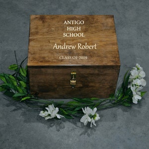 May include: A wooden box with a hinged lid and a lock. The box is engraved with the text "Antigo High School", "Andrew Robert", and "Class of 2019".