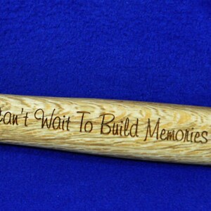 May include: A 16 ounce hammer with a wooden handle. The handle is engraved with the text "Dad, I Can't Wait To Build Memories Together! Love, Cora".
