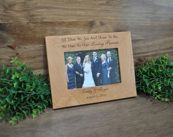 May include: A wooden picture frame with a personalized inscription: "All That We Are And Hope To Be, We Owe To Our Loving Parents." The frame also includes the names "Emily & Roger" and the date "August 3, 2016". A photo of a family is displayed in the frame.