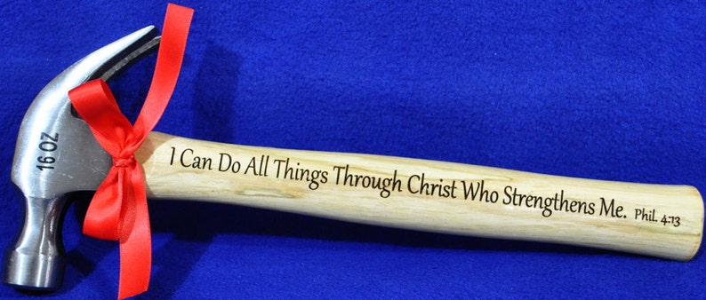 Peut inclure: Un marteau de 16 onces avec un manche en bois. Le manche est grav&eacute; du texte "Je peux tout faire par Christ qui me fortifie. Phil. 4:13".