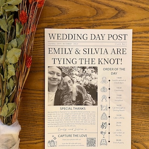May include: A wedding day announcement poster featuring a black and white photograph of two women in the centre. The poster is titled "Wedding Day Post" and includes the names "Emily & Silvia" with the text "Tying the Knot!" The poster also features a schedule of events for the day, including the ceremony, reception, and cake cutting.