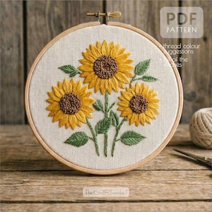 May include: Embroidered sunflower design in a wooden hoop. The sunflowers are yellow with brown centers and green leaves. The text "PDF PATTERN" is visible in the upper right corner. The text "thread colour suggestions" is also visible.