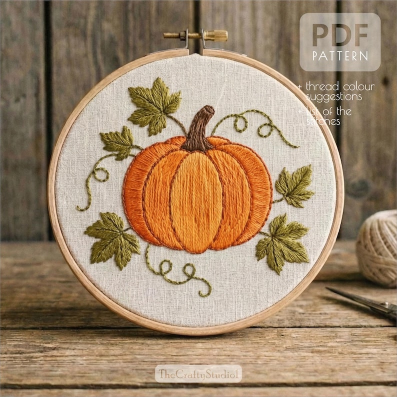 May include: Embroidered pumpkin in a wooden hoop. The pumpkin is orange with a brown stem, surrounded by green leaves and vines. The text "PDF PATTERN" is visible in the upper right corner. The text "The Crafty Studio!" is visible at the bottom.