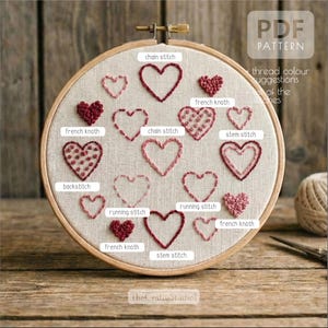 May include: Embroidered heart pattern in a wooden hoop. The design features various stitches like chain, stem, and running stitches, with the text "PDF PATTERN" and "TheCraftyStudio1". The hearts are in shades of red and pink.