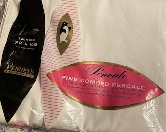 May include: A white twin bed sheet in a plastic package with a pink and gold label that reads "Fine Combed Percale 94% Upland Cotton 6% Pima Cotton". The label also says "Finished thread count averages 186 per inch square for a luxurious, high-count weave that wears, feels and looks better".
