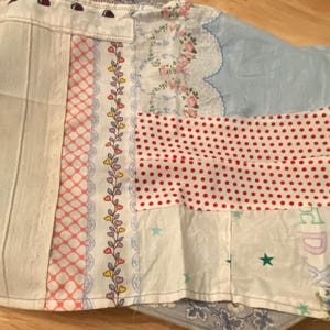 Può includere: Un tessuto patchwork con una varietà di motivi, tra cui pois, cuori e motivi floreali. Il tessuto è cucito insieme in un motivo casuale, creando un design unico e colorato.