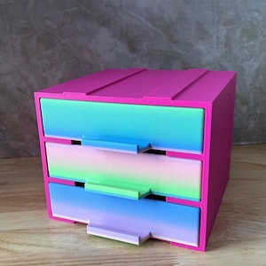 May include: A white ceramic mug with a black handle and the text "But First, Coffee" in a black, bold font. The mug is on a white surface. The mug is approximately 4 inches tall.