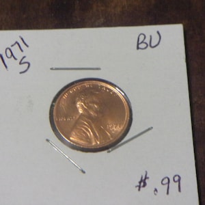 Op de afbeelding: Een 1971-S Lincoln penny in briljante ongecirculeerde staat, getoond op een witte kaart met de tekst "BU" en "€ 0,99".