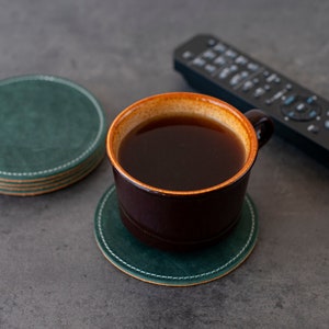 Bring a touch of nature indoors with this set of 4 handcrafted leather coasters in a vibrant emerald green.