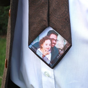 May include: A brown patterned tie with a photo card attached. The photo card shows a man and a young girl smiling. The text on the card reads "Forever your little girl" and "24.6.2023".