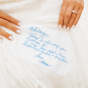 Étiquette personnalisée pour robe de mariée brodée de votre mot manuscrit en souvenir de vos proches. Ecriture manuscrite personnalisée en bleu pour la mariée