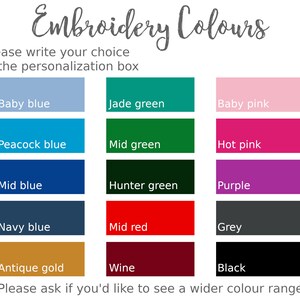 May include: A chart of embroidery thread colors with the title "Embroidery Colors". The colors include baby blue, jade green, baby pink, peacock blue, mid green, hot pink, mid blue, hunter green, purple, navy blue, mid red, grey, antique gold, wine, and black. The text "Please write your choice in the personalization box" is at the top of the chart. The text "Please ask if you'd like to see a wider color range" is at the bottom of the chart.
