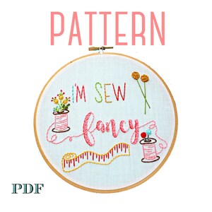 May include: Embroidery pattern for a hoop art project featuring the text "I'm Sew Fancy" with colourful thread, a spool of thread, a measuring tape, and flowers.