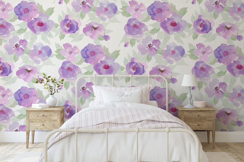 May include: A white bed with a pink and white striped duvet and a white pillow with the text "Good night" on it. The bed is in front of a wall with a purple and white floral pattern.