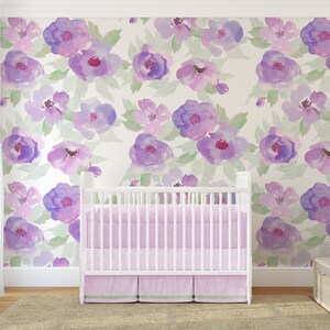 May include: A white cot with a pink and green striped cot bedding set in a nursery with a purple floral wallpaper.