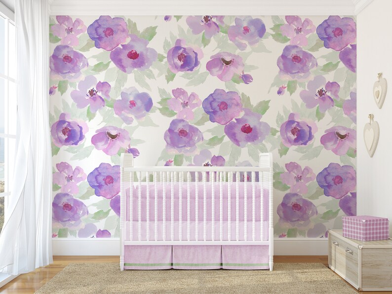 May include: A white cot with a pink and green striped cot bedding set in a nursery with a purple floral wallpaper.