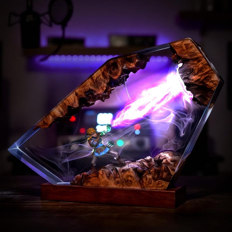 May include: A decorative resin sculpture featuring a miniature figure emitting a beam of purple energy. The sculpture is encased in a clear, geometric form with a wooden base and intricate wood grain details. The energy beam is bright and vibrant.