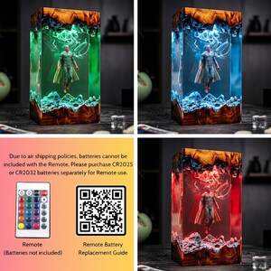 May include: A rectangular resin lamp featuring a superhero figure, with a wooden base and top. The lamp's interior glows with green, blue, and red light. The image also includes a remote control and a QR code.