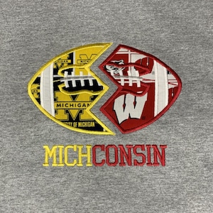 May include: A gray sweatshirt with a yellow and red embroidered design of a football split in half, with the University of Michigan logo on one side and the University of Wisconsin logo on the other. The text "MICHICONSIN" is embroidered below the design.