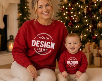 Puede incluir: Un conjunto a juego de dos sudaderas de cuello redondo en color rojo oscuro, una de talla adulta y otra de talla infantil, ambas con un gráfico circular blanco en el pecho con el texto "YOUR DESIGN HERE" impreso en una fuente sans-serif.