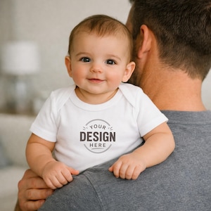 Puede incluir: Un body blanco de manga corta para beb&eacute; con un gr&aacute;fico circular en el pecho que incluye el texto "YOUR DESIGN HERE" en letras gris oscuro. La prenda cuenta con un cuello redondo y mangas sencillas, ofreciendo una superficie personalizable.