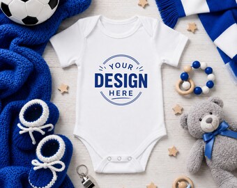 May include: A white short-sleeved baby bodysuit featuring a blue circular graphic with the text YOUR DESIGN HERE in the center. The garment has a round neckline and three snap closures at the bottom, designed for infants with a simple, clean aesthetic.