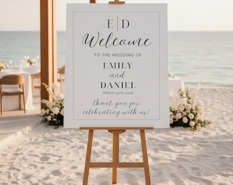 May include: A white rectangular wedding welcome sign on a wooden easel featuring black text that reads E D, Welcome to the wedding of Emily and Daniel, March 14th, 2026, and Thank you for celebrating with us, enclosed within a thin black border.