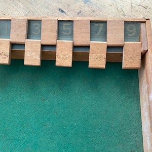May include: A wooden game board with a green felt playing surface and a numbered scoring area at the top. The numbers 1, 3, 5, 7, and 9 are visible.