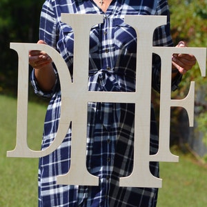May include: A set of three large, wooden letters spelling "DHF" in a simple, modern font. The letters are unfinished and have a natural wood color.