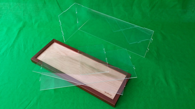 Op de afbeelding: Een houten displaykast met een transparant acryldeksel. De kast is gemaakt van licht hout met een donkerbruine lijst. De kast is leeg en klaar om items te tonen.