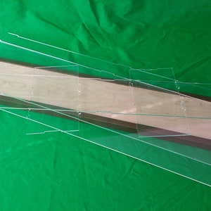 May include: A set of clear acrylic display cases with a brown wooden frame. The cases are stacked on top of each other and are ready to be assembled.