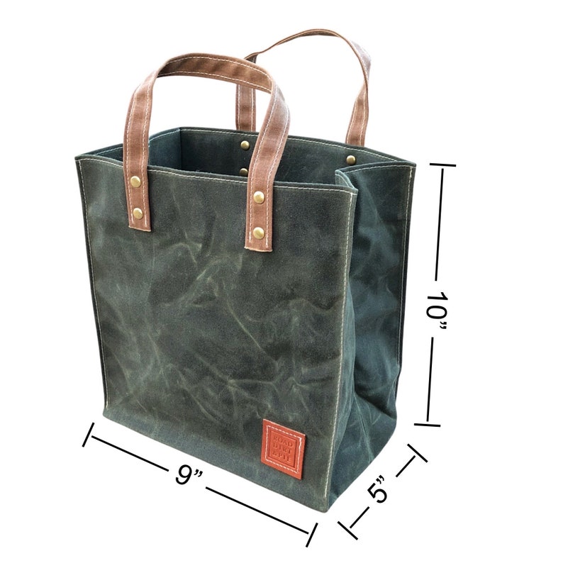 A small, handcrafted tote bag measurement image. 9 inches wide, 5 inches deep, and 10 inches tall. Waxed canvas is eco-friendly, anti microbial and naturally weather resistant. Made in the USA by Road Dirt and Pie.