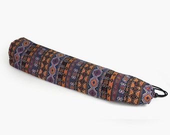May include: A long, cylindrical yoga mat with a drawstring closure. The mat is covered in a colorful, geometric pattern with shades of blue, orange, and brown.
