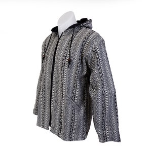 May include: A black and white patterned hooded jacket with a zip closure. The jacket has a geometric design and a black hood.