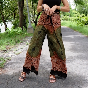 May include: Green and orange patterned pants with a wrap-around style. The pants have a black trim and are made of a lightweight fabric.