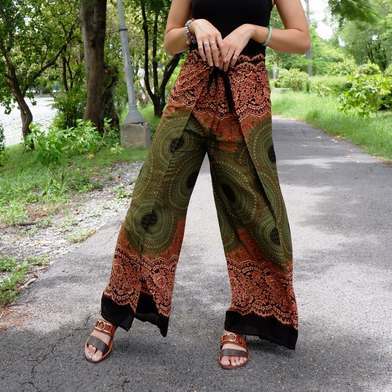 May include: Green and orange patterned pants with a wrap-around style. The pants have a black trim and are made of a lightweight fabric.