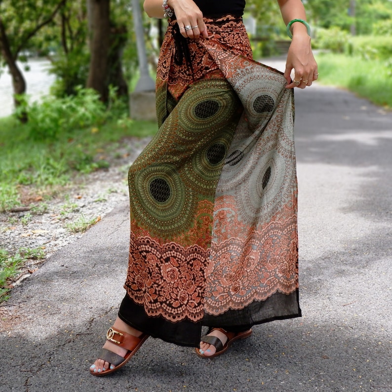 May include: A long, flowing skirt with a black, green, and orange mandala print. The skirt is made of a lightweight fabric and has a wrap-around style.