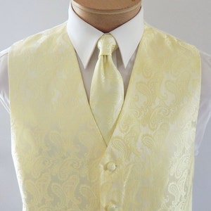 May include: A yellow paisley patterned waistcoat with a matching tie. The waistcoat has a V-neck and five buttons down the front.