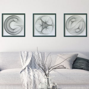 Puede incluir: Tres piezas de arte de cuerda en blanco y negro enmarcadas con dise&ntilde;os geom&eacute;tricos. Los marcos son de color verde oscuro y el fondo es blanco.
