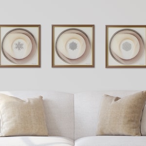 May include: Three framed wall art pieces with a geometric design in the center of each. The frames are brown wood with a gold trim. The background of each piece is a light brown with a darker brown swirl design.