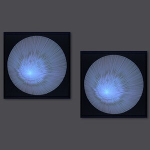 May include: Two framed black and white abstract art prints with a blue and white circular design. The circular design is made up of thin lines radiating from the centre.